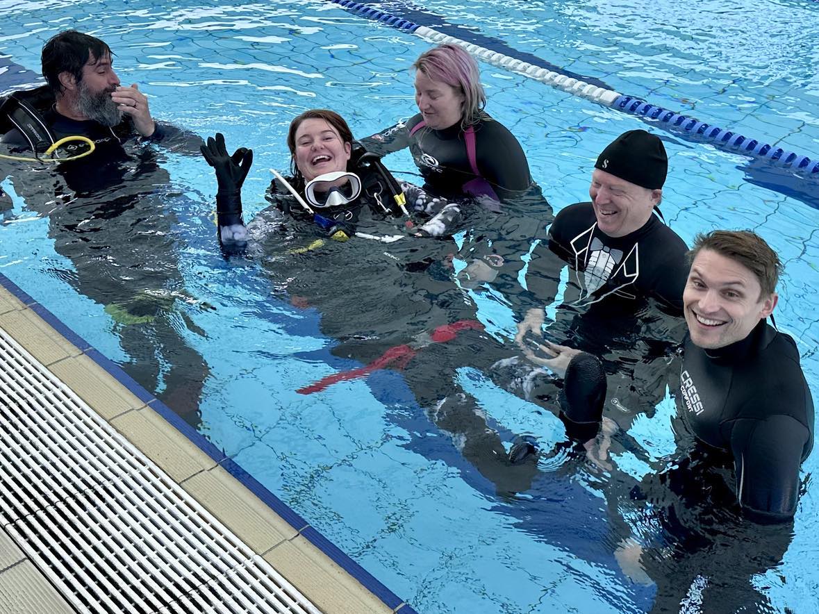 Divers helping a "disabled" diver into the water during training